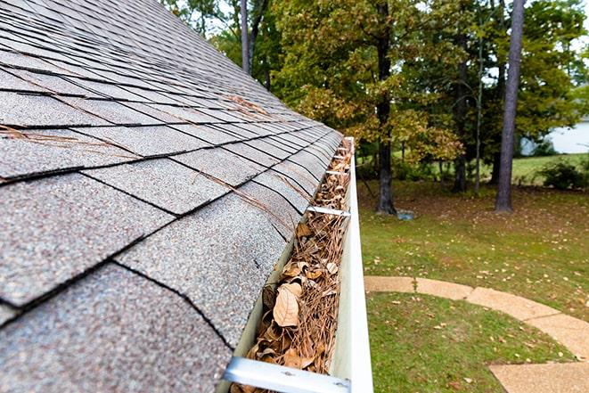 skilled technician cleaning out clogged gutters